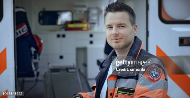 porträt von männlichen stehen neben krankenwagen sanitäter - paramedics stock-fotos und bilder