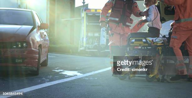 paramedics holding car victim on stretcher - low section woman stock pictures, royalty-free photos & images
