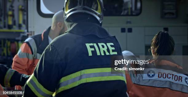 paramedics and firefighters at car accident - firemen at work stock pictures, royalty-free photos & images