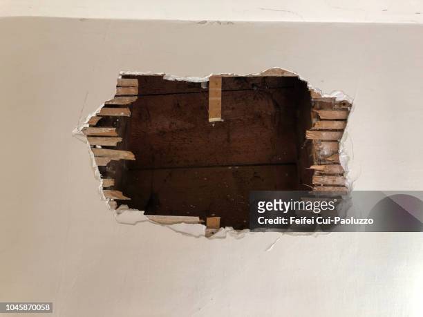 a big hole on the wall in an  abandoned building at vevey, switzerland - hole ストックフォトと画像