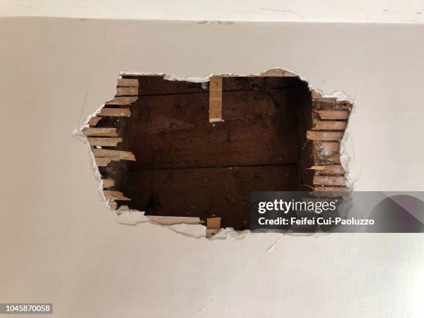 a big hole on the wall in an  abandoned building at vevey, switzerland - abandoned crack house stock pictures, royalty-free photos & images