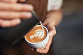 Coffee Art In Cup. Closeup Of Hands Making Latte Art