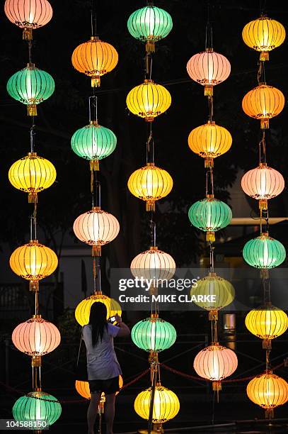 Woman photographs giant lanterns displayed as part of Mid-autumn festival celebration at a park in Hong Kong on September 22, 2010. The Mid-Autumn...