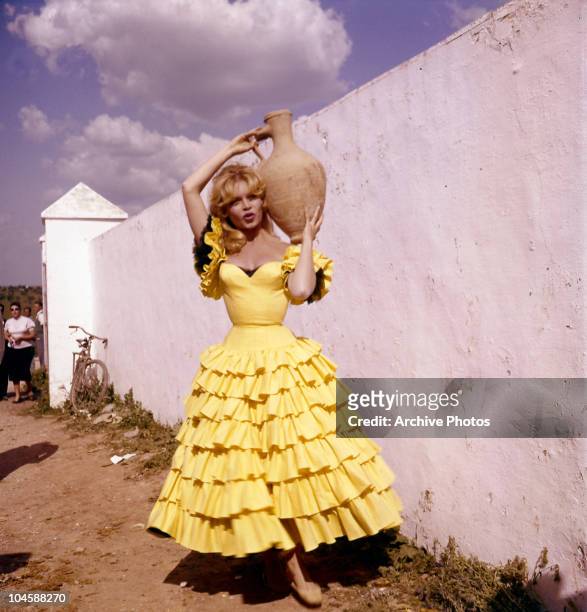 Portrait of French actress Brigitte Bardot in Spanish dress holding a jug, circa 1960s.