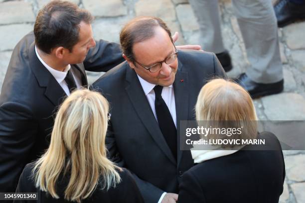Former French President Francois Hollande pays his respects to Aznavour's widow Ulla and daughter Katia as they arrive to attend the national homage...