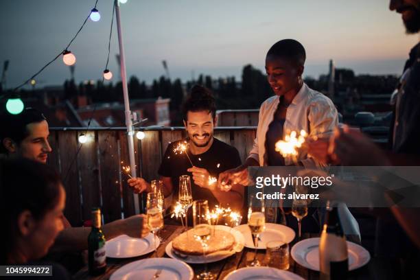 multietniska vänner njuter rooftop party - cake party bildbanksfoton och bilder