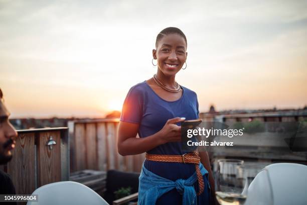 femmina alla festa sul tetto con telefono - hipster persona foto e immagini stock