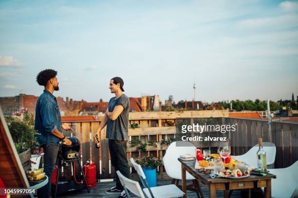 friends chatting at barbecue party on rooftop - rooftop bbq stock pictures, royalty-free photos & images