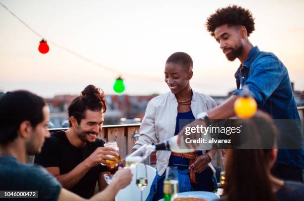 multi-ethnischen freunde genießen sie drinks an wiedervereinigung grillparty - after work drinks stock-fotos und bilder