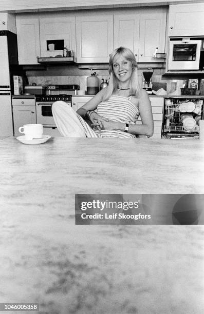 Portrait of Swedish Pop musician Agnetha Faltskog, of the group ABBA, as she sits behind a table in her kitchen, Stockholm, Sweden, July 1977.