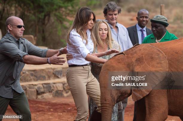 Secret Service Agent helps to steady US First Lady Melania Trump after she got bumped by a baby elephant at the David Sheldrick Elephant Orphanage in...