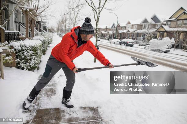 man shoveling snow in winter - winterdienst stockfoto's en -beelden