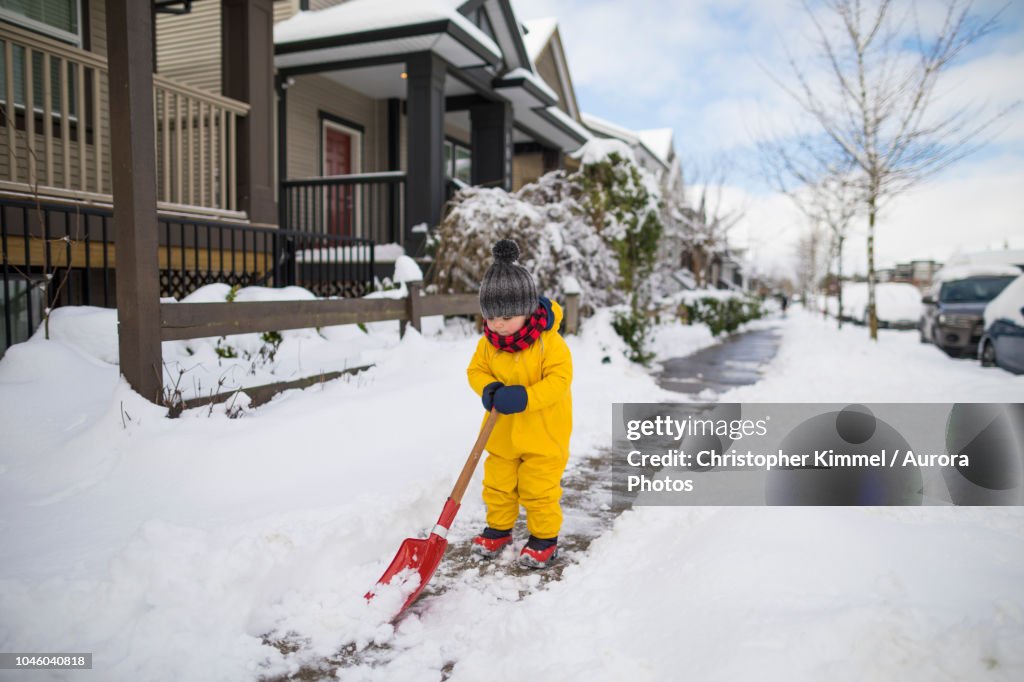 Toddler shoveling snow