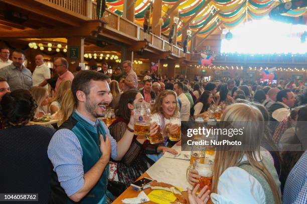 Group of young people cheering with beers on Day 12 of the Oktoberfest. The Oktoberfest is the largest Volksfest in the world. It will take place...