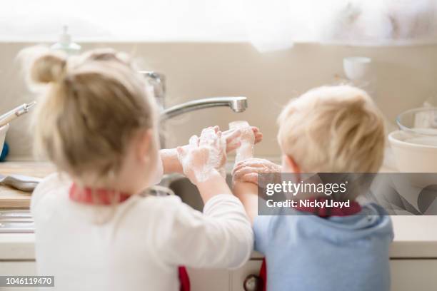 afwas op het aanrecht - child washing hands stockfoto's en -beelden