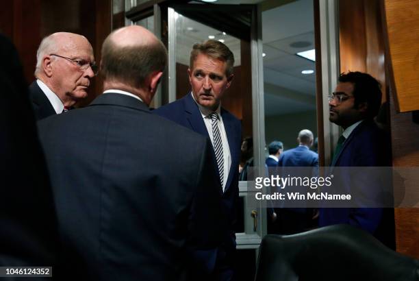 Sen. Jeff Flake confers with Democratic senators Sen. Patrick Leahy and Sen. Chris Coons while leaving a Senate Judiciary Committee meeting in the...