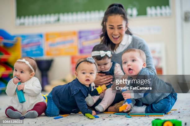 babys, die spaß in der kindertagesstätte - puériculture stock-fotos und bilder