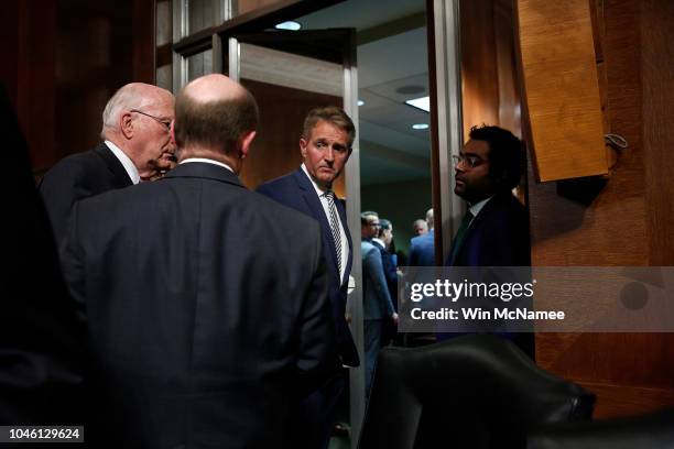 Sen. Jeff Flake confers with Democratic senators Sen. Patrick Leahy and Sen. Chris Coons while leaving a Senate Judiciary Committee meeting in the...