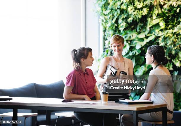 meeting in the office common area - living_walls stock pictures, royalty-free photos & images