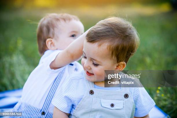 schattige tweeling buiten - cute twins stockfoto's en -beelden