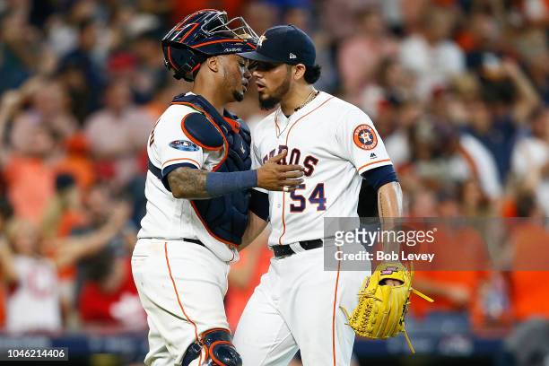 Roberto Osuna of the Houston Astros celebrates with Martin Maldonado after they defeated the Cleveland Indians 7-2 in Game One of the American League...