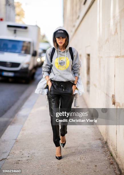 Alexandra Lapp wearing a light grey, fitted down jacket with inner carriers by Airfield, a handmade grey Hoodie with hand-painted print by Wodka...