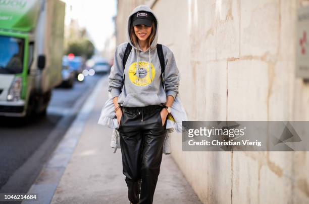 Alexandra Lapp wearing a light grey, fitted down jacket with inner carriers by Airfield, a handmade grey Hoodie with hand-painted print by Wodka...