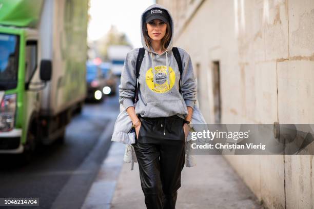 Alexandra Lapp wearing a light grey, fitted down jacket with inner carriers by Airfield, a handmade grey Hoodie with hand-painted print by Wodka...