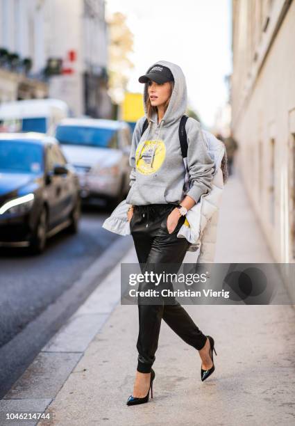 Alexandra Lapp wearing a light grey, fitted down jacket with inner carriers by Airfield, a handmade grey Hoodie with hand-painted print by Wodka...