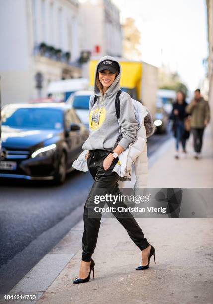 Alexandra Lapp wearing a light grey, fitted down jacket with inner carriers by Airfield, a handmade grey Hoodie with hand-painted print by Wodka...