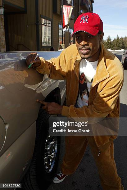 Darrin Dewitt Henson autographs a 2005 Chevrolet Silverado Pickup which General Motors will donate to the National Ability Center, a local charity...