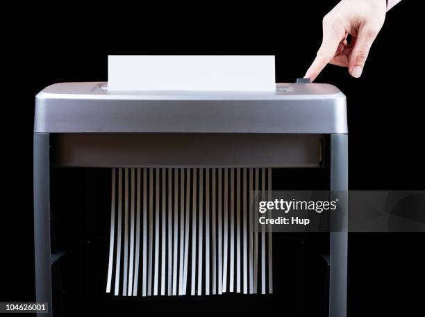 hand operating paper shredder  - em tiras imagens e fotografias de stock