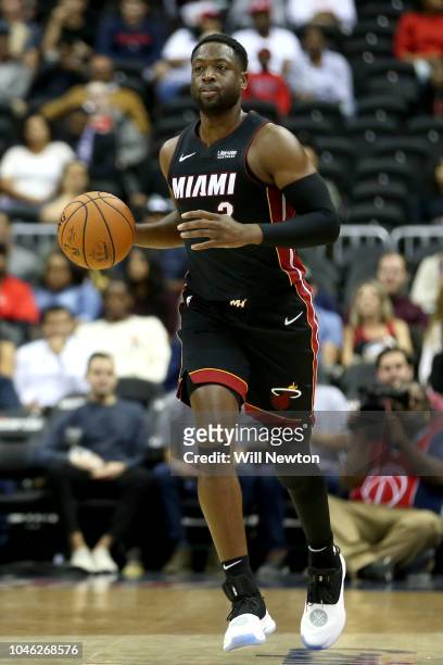 Dwyane Wade of the Miami Heat dribbles the ball against the Washington Wizards during the first half of a preseason NBA game at Capital One Arena on...