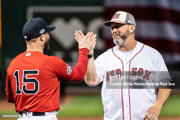 Former Boston Red Sox player Trot Nixon reacts with Dustin Pedroia after throwing out the ceremonial first pitch before game one of game one of the...