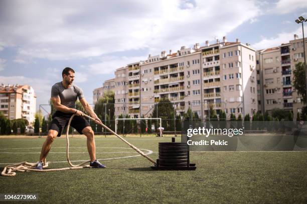 man pulling gym sled - pulling stock pictures, royalty-free photos & images