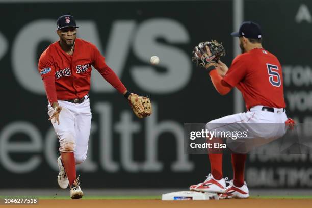 Xander Bogaerts of the Boston Red Sox tosses the ball to Ian Kinsler to make the force out at second against the New York Yankees in the sixth inning...