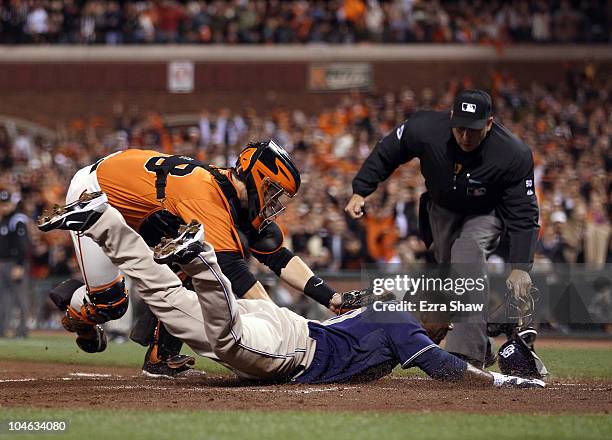 Miguel Tejada of the San Diego Padres is tagged out by Buster Posey of the San Francisco Giants when Tejada tried to score from first base on a hit...