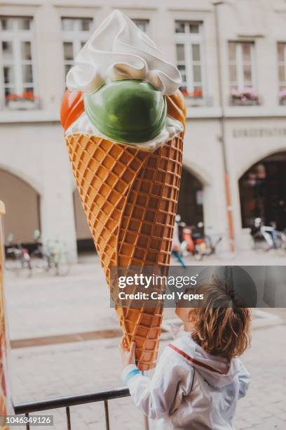 boy pretending to eat a fake ice cream at street - ville de berne photos et images de collection