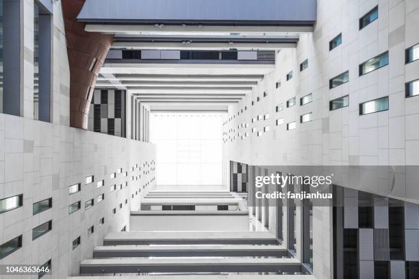 looking up from the atrium of a highrise building - building symmetry stock pictures, royalty-free photos & images