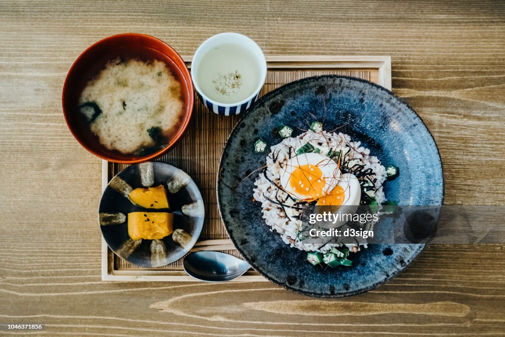 Flat lay of delicate Japanese meal with appetizer, miso soup and tea freshly served on table in a restaurant