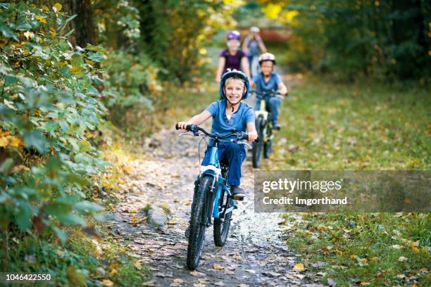 little boy and his family riding bicycles in nature - 2018 cycling stock pictures, royalty-free photos & images