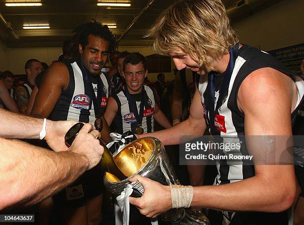 Dale Thomas of the Magpies fills up the Premiership Cup with champagne after the Magpies won the AFL Grand Final Replay match between the Collingwood...