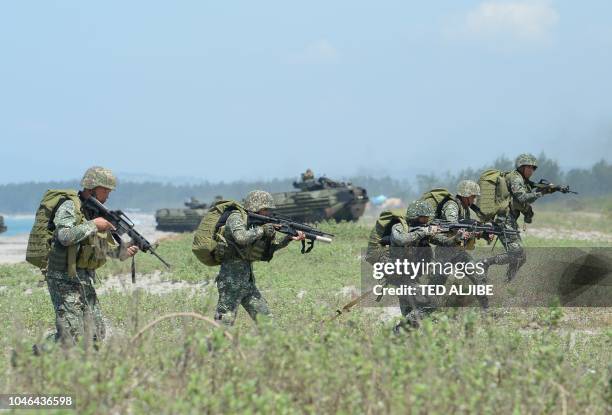Philippine marines take position next to US marines Amphibious Assault Vehicles during an amphibious landing exercise at the beach of the Philippine...