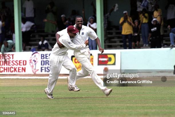 Courtney Walsh of the West Indies celebrates with Jimmy Adams as he has Henry Olonga caught by Wavell Hinds to claim his 435th wicket, breaking Kapil...