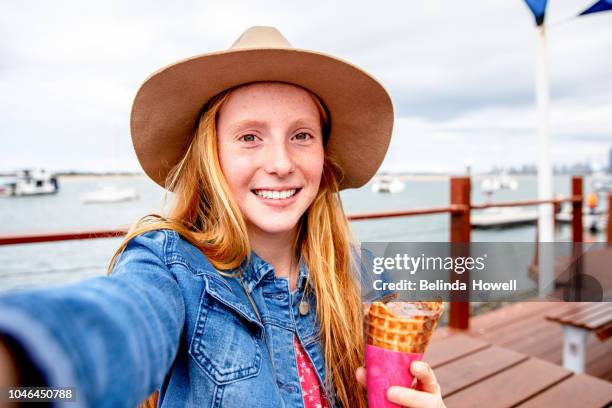 two red headed girls and little boy eat ice cream together by the ocean - boy and girl eating ice cream stock-fotos und bilder