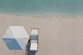 3d rendering of beach with chair and sunshade in top view