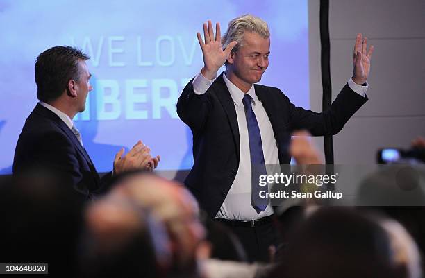 Dutch right-wing politician Geert Wilders , flanked by German renegade former Christian Democrat Rene Stadtkewitz, waves to supportersafter speaking...