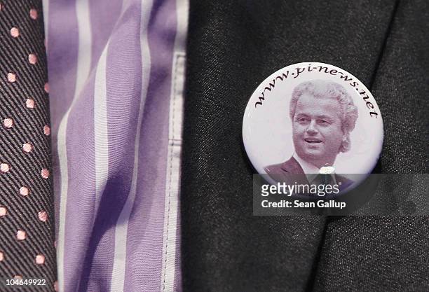 Supporter of Dutch right-wing politician Geert Wilders wears a button on his jacket showing a portrait of Wilders before Wilders spoke on October 2,...