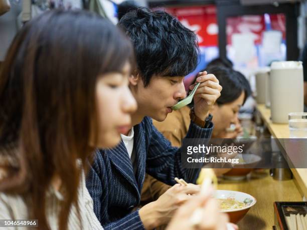 chinese couple on vacation in tokyo japan ramen shop - ramen noodles stock pictures, royalty-free photos & images