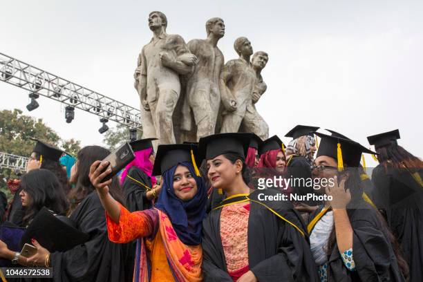 Group of graduates expressing their delight in front of the sculpture Raju at TSC area, on the 51th convocation of the students of Dhaka University...